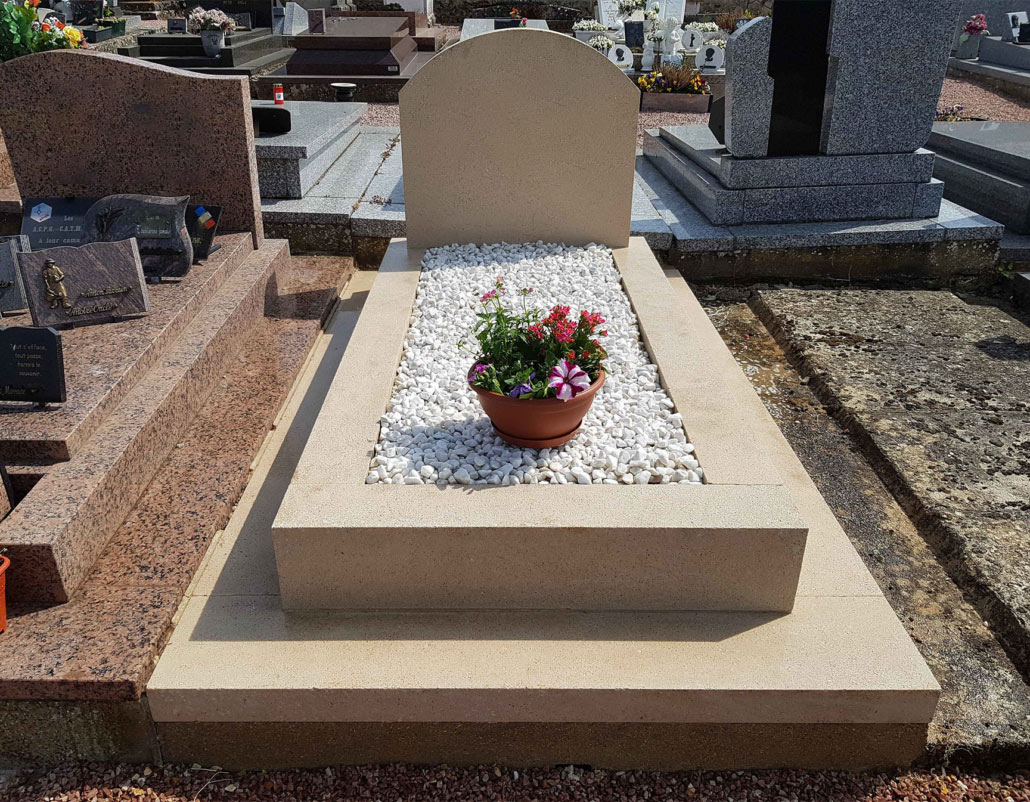 Tombe familiale moderne en pierre claire avec une dalle rectangulaire entourant un lit de gravier blanc et une potée de